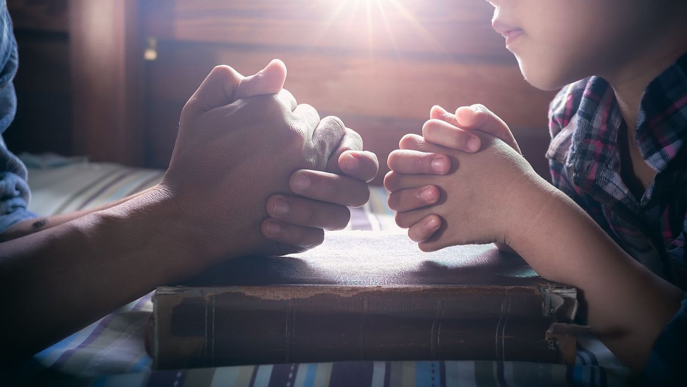 apa és fia iádkozik Biblia felett