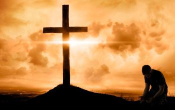 Kneeling at the Cross of Jesus – photo: ninjaMonkeyStudio / GettyImages / Canva